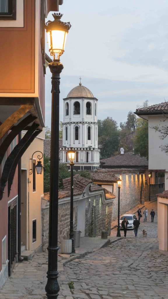 Plovdiv, Europäische  Kulturhauptstadt 2019: Blick durch eine Altstadtgasse auf den Turm der orthodoxen Kirche Konstantin und Elena in Plowdiw am Abend