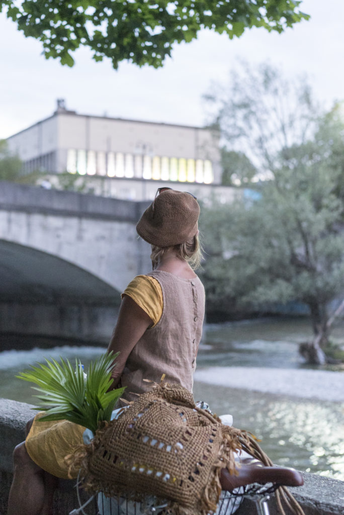 Frau blickt über die Isar zum Deutschen Museum in München / woman looking across Isar river to the Deutsches Museum in Munich, 5.7.2019, Foto: Robert B. Fishman